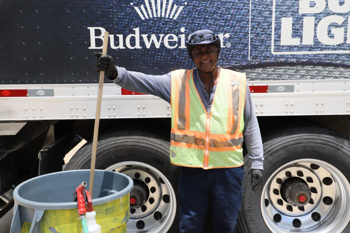 A Del Papa employee stands in front of a truck with a cleaning cart.