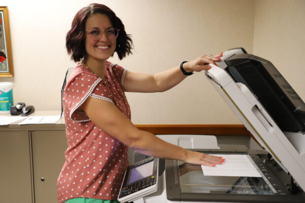 A Del Papa employee stands at a copy machine.